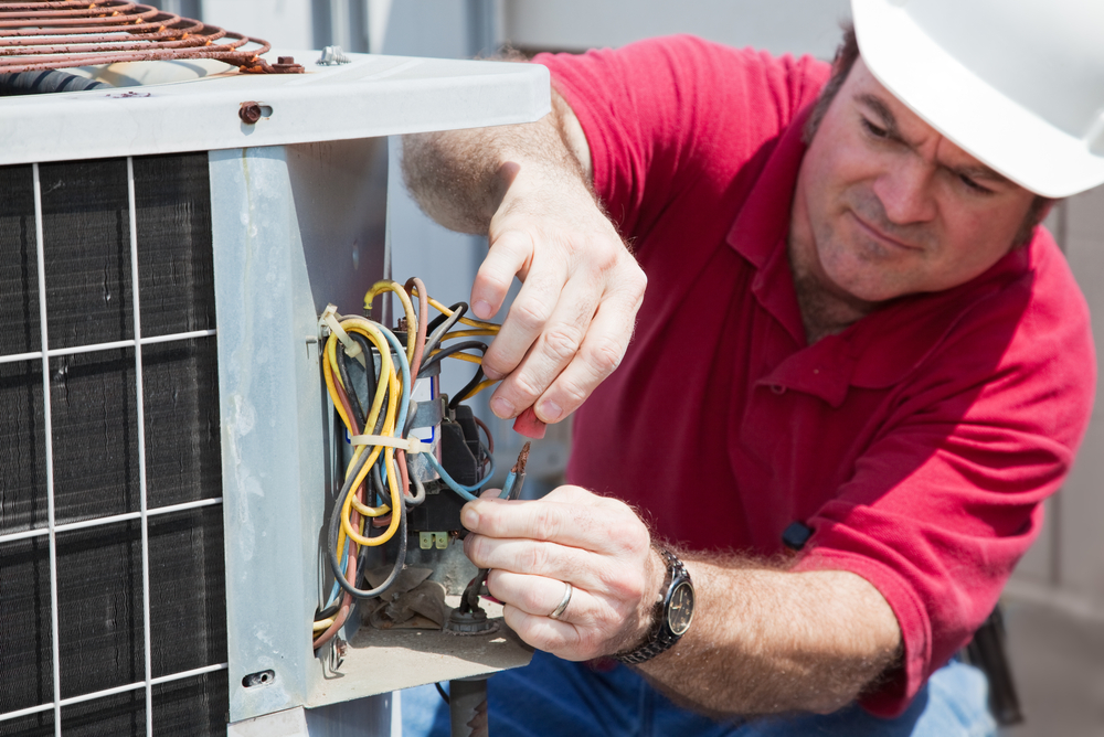 image of an air conditioning repair person fixing an AC unit